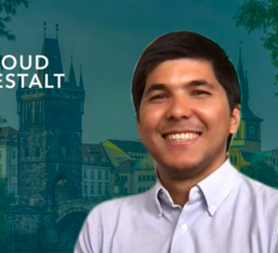 Foto unseres Teammitgliedes Ilkhom mit Prag im Hintergrund und dem Cloud Gestalt Logo